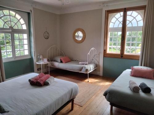 1 dormitorio con 2 camas y 2 ventanas en Moulins de Clan, en Jaunay-Clan