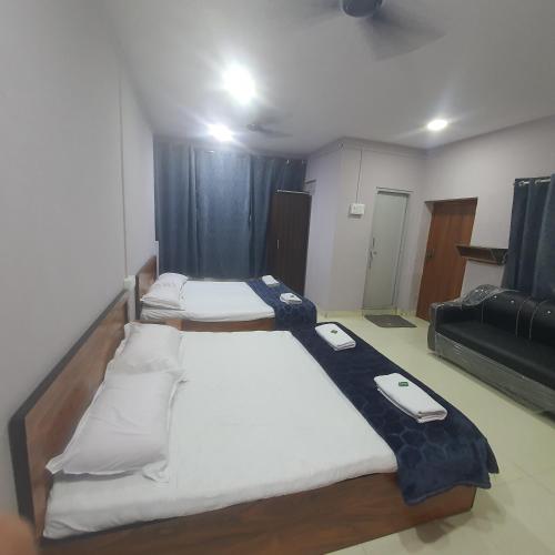 a room with three beds in a room at Hotel Family Stay Beside Railway Station in Aurangabad