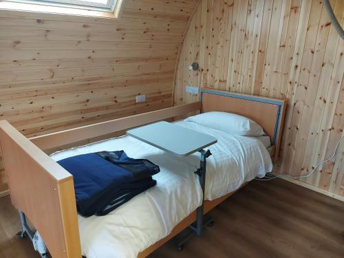 a small room with a bed in a wooden cabin at Callander Hostel in Callander