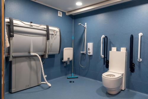 a bathroom with a toilet and a blue wall at Callander Hostel in Callander