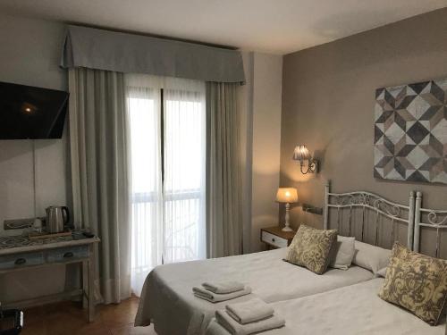 a bedroom with a bed and a large window at Hotel Macavi Playa in Rota