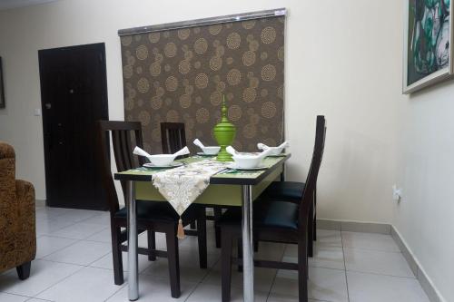 a dining room table with chairs and a green vase on it at ChallawaRiver Homes in Calabar