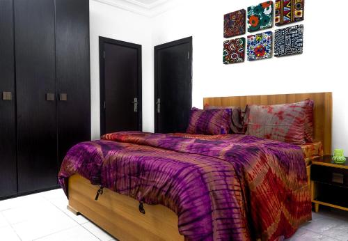 1 dormitorio con 1 cama con edredón morado en ChallawaRiver Homes, en Calabar