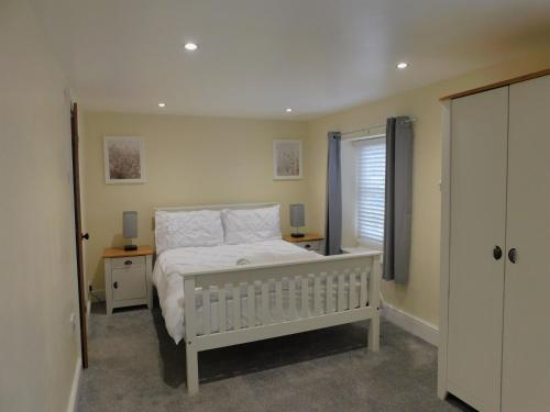 a bedroom with a white bed and a window at St Christophers Cottage, Sheringham - Keys Holiday Cottages in Sheringham