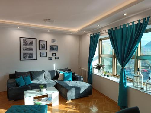 Una sala de estar con un sofá y una ventana. en Korzo Apartment, Subotica, en Subotica
