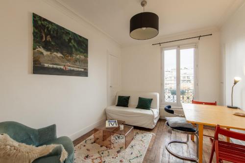 a living room with a table and a couch at Voltaire Cosy appartement au centre de Paris in Paris