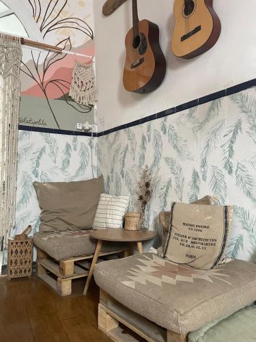 a living room with a couch and a guitar on the wall at Casa Calma Yoga Hostel in Agaete