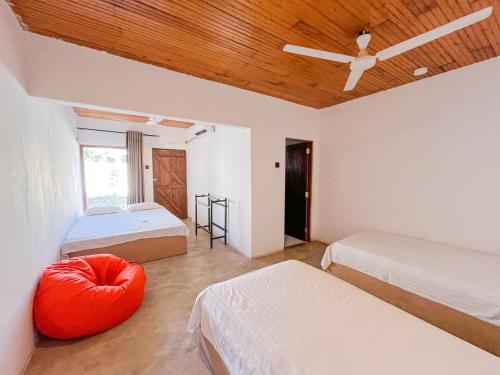 a bedroom with two beds and a wooden ceiling at Agastyā in Kataragama