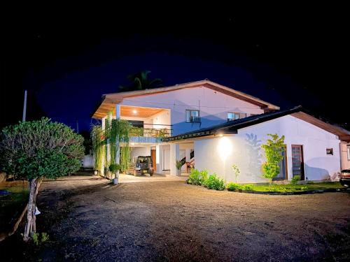a large white house with a driveway at night at Agastyā in Kataragama