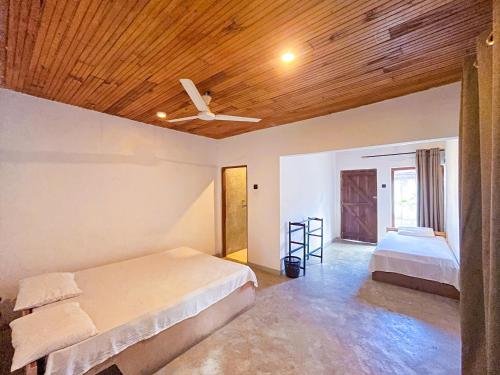 a bedroom with a bed and a ceiling fan at Agastyā in Kataragama