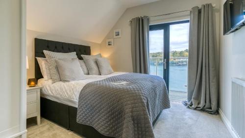 a bedroom with a bed with a view of the water at Glan y Mor Menai in Menai Bridge