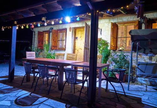 a wooden table and chairs on a patio at night at Despina country retreat in Paphos City