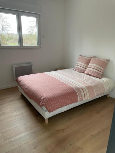 ein Schlafzimmer mit einem Bett mit zwei Kissen darauf in der Unterkunft Les Chalets du Mancel - Chalet Victor - 500 m Bouleries Jump , 10 min du circuit des 24h in Parence