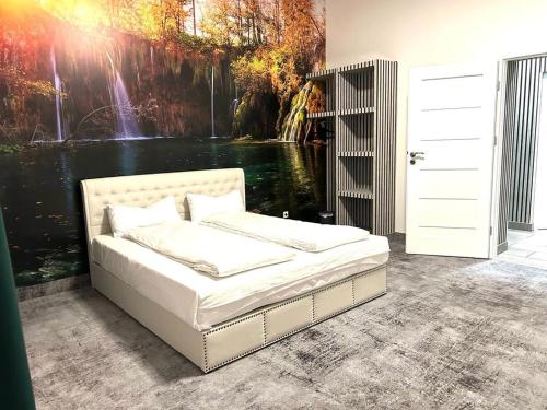 a bedroom with a bed and a painting of a waterfall at Weißes Haus in Plauen