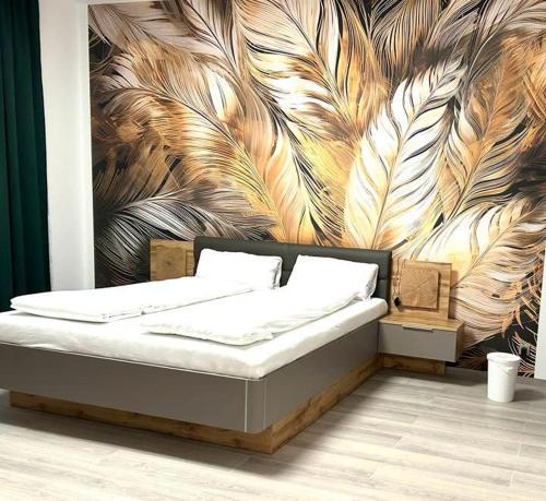 a bedroom with a bed with a mural of feathers at Weißes Haus in Plauen