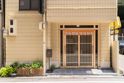 een ingang naar een gebouw met een grote houten deur bij 大阪道顿堀 铁甲猫の家 in Osaka