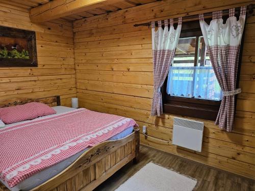 a bedroom with a bed in a log cabin at Chata na Lazoch so saunou - Raj v prírode in Lazy pod Makytou