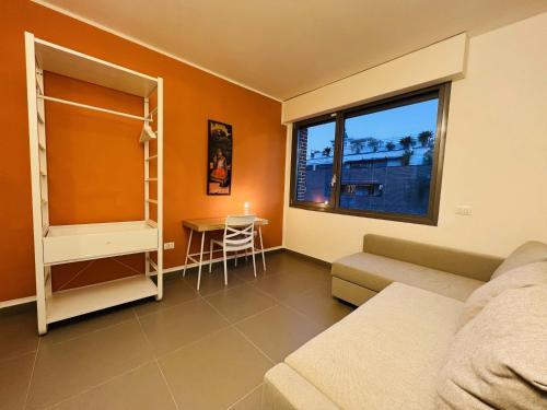 a room with a bed and a table and a window at Sebeto Apartment in Naples