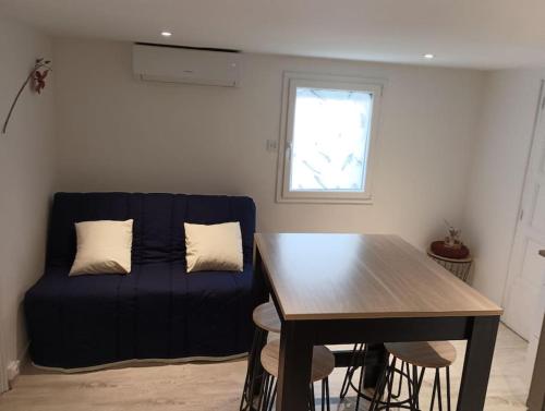 un salon avec un canapé bleu et une table dans l'établissement Chez Rémi, à Meximieux