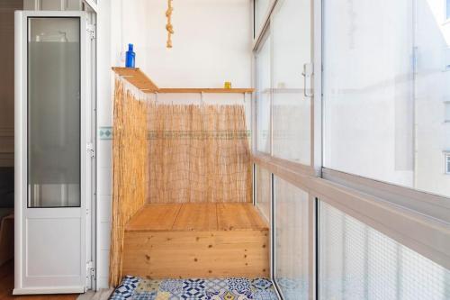 ein kleines Zimmer mit einer Holzbank neben einer Tür in der Unterkunft Spacious apartment near Saldanha in Lissabon