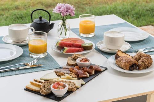 a table with a tray of breakfast foods and orange juice at Hotel Sa Franquesa Nova in Vilafranca de Bonany