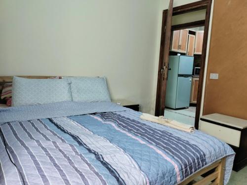 ein Schlafzimmer mit einem Bett mit einer blau gestreiften Decke in der Unterkunft Maadi ring road Family apartment in Kairo