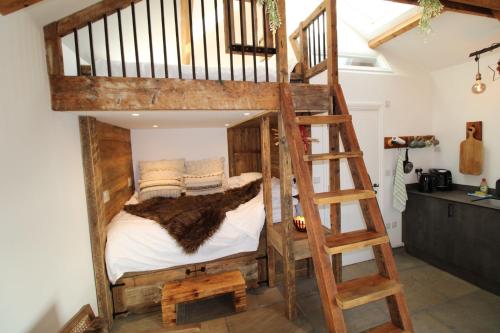 a wooden bunk bed in a room with a ladder at The Bullpen Warton in Warton