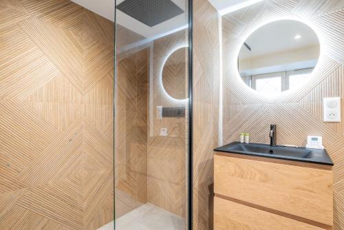une salle de bain avec une douche avec un lavabo et un miroir dans l'établissement Terrasse vue sur Ill - Cœur Petite France, à Strasbourg