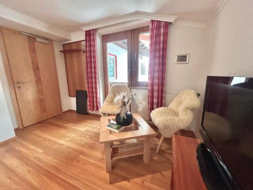 a living room with two chairs and a table at Haus Wallis by stayFritz - Ski-In Ski-Out Zimmer 'garni' am Arlberg in Warth am Arlberg