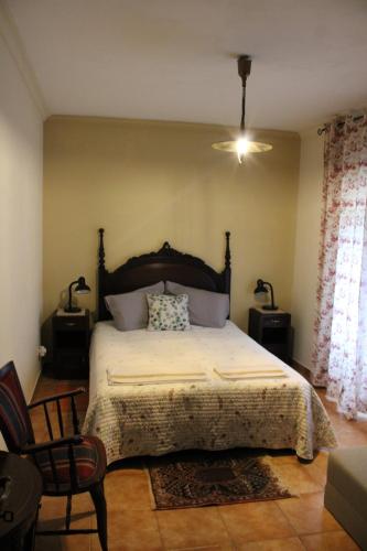 a bedroom with a large bed and two chairs at Zion Jardim Monsanto in Monsanto