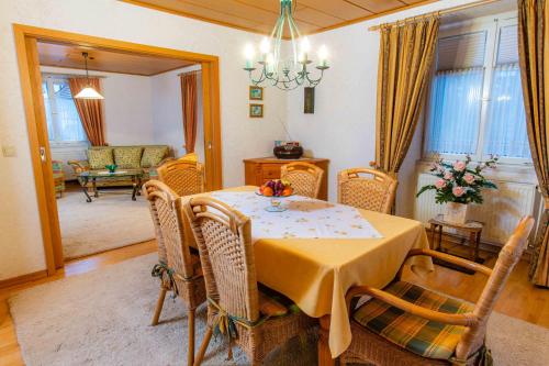 a dining room with a table and wicker chairs at Ferienwohnungen Im Kelterhaus in Bad Herrenalb