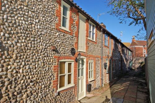 シェリンガムにある2 Museum Cottagesの石壁の古い石造りの建物