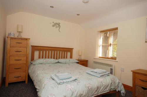a bedroom with a bed with two towels on it at 2 Museum Cottages in Sheringham