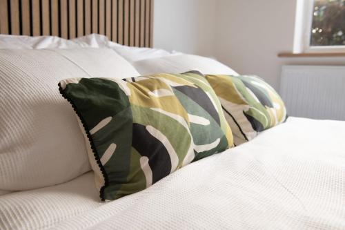 um grupo de almofadas sentado numa cama em Dorset Stylish Apartment em Poole