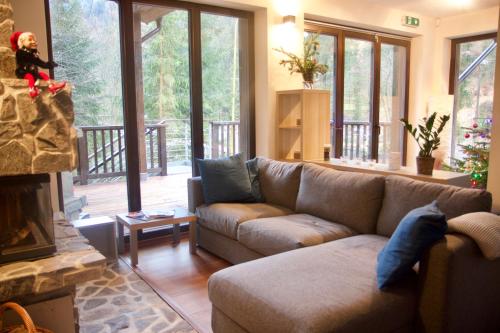 a living room with a couch and a fireplace at The Dragon's Lair Chalet in Belá
