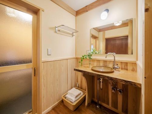 uma casa de banho com um lavatório e um espelho em Sumire-an Machiya House em Quioto
