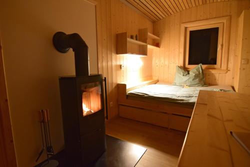 a small room with a bed and a stove at Esperanzahof in Oberndorf an der Melk