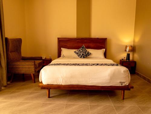 a bedroom with a large bed and a chair at Star View Hotel Restaurant and Bar in Kampala