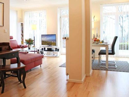 Una sala de estar con un sofá rojo y una mesa. en Am Dünenweg Uns Hüsung Whg 3, en Boltenhagen