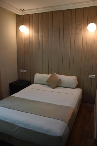 a bedroom with a large bed with two pillows at Cadé Hotel in Casablanca