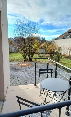a table and chairs on a balcony with a view of a river at Gîte "Fleur de Jeannette" in Torpes