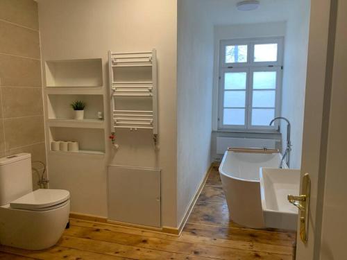 a bathroom with a tub and a toilet and a sink at 170m2 apartment in Historical building in Gutenzell-Hürbel