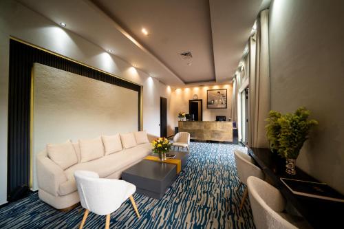 a living room with a white couch and chairs at Hotel Le Rocher Marrakech in Marrakech