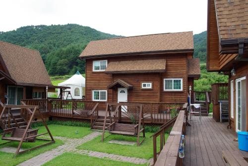 a deck with chairs and a house with a tent at Cabin Liun in Pyeongchang