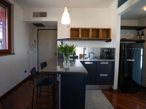 a kitchen with a vase of flowers on a counter at Bastia RF Balcony up to 3 guests - Scalo Romana Olimpico Prada Bocconi IEO IED Forum DUOMO15min in Milan