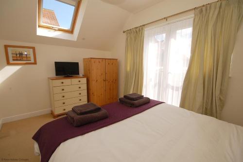 a bedroom with a bed with two towels on it at 2 Old Dairy Court in Sheringham