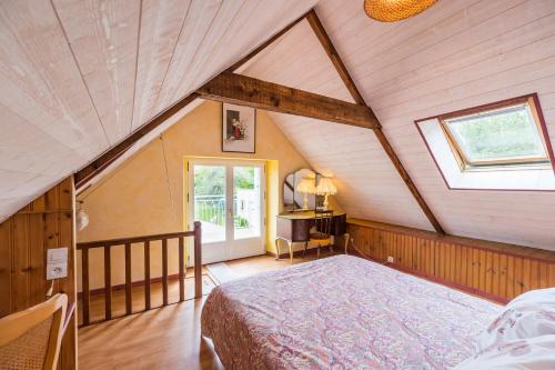 a attic bedroom with a bed and a window at Maison Isabelle in Plouézec