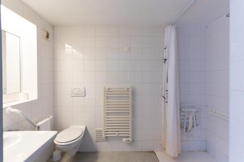 La salle de bains blanche est pourvue de toilettes et d'un lavabo. dans l'établissement KYRIAD CREIL - Chantilly Nord, à Creil