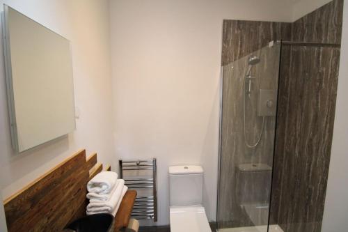 a bathroom with a toilet and a glass shower at The Beehive Warton in Warton