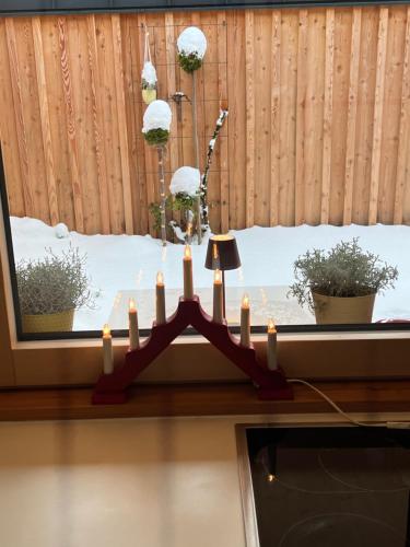 a chandelier in front of a window with snow at Stadtfüchse plus Sauna in Bad Ischl